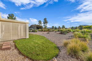 View of grassy yard with a sunroom