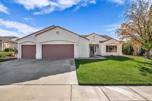 Mediterranean / spanish home featuring a front yard, stucco siding, an attached garage, driveway, and a tiled roof