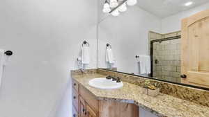 Full bathroom featuring vanity and a shower stall