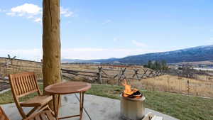 View of patio / terrace with a mountain view, a fire pit, and a rural view