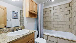 Bathroom featuring vanity, tiled shower / bath combo, and recessed lighting