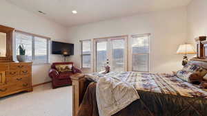 Bedroom featuring light carpet, access to exterior, and recessed lighting