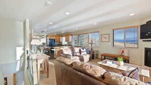 Living area with a glass covered fireplace, light wood-style floors, and recessed lighting