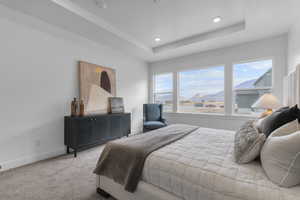 Bedroom with carpet, a mountain view, a raised ceiling, and recessed lighting