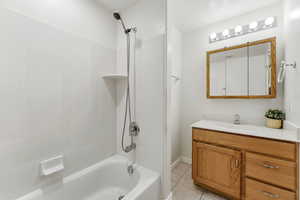 Full bathroom featuring shower / bathtub combination, vanity, and light tile patterned flooring