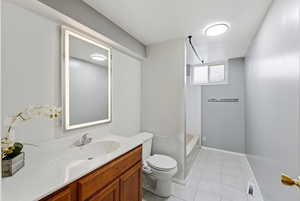 Bathroom featuring vanity, washtub / shower combination, and light tile patterned floors