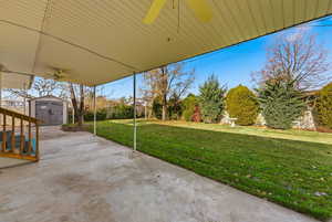 View of patio featuring a ceiling fan and a storage shed