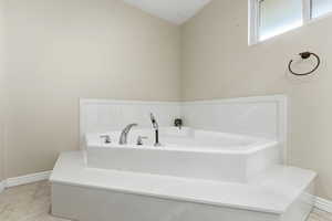 Bathroom featuring a bath and light tile patterned floors.  Huge Huge Huge Bathroom