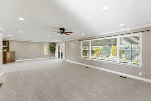 Unfurnished living room featuring crown molding, light colored carpet, and recessed lighting