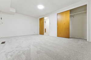 Bedroom 3 - brand new carpet, a double closet, and a textured ceiling.  I would enclose the water pipe. or put a closet in front of it.