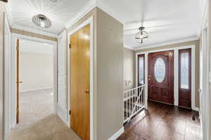 Entrance foyer with ornamental molding and baseboards