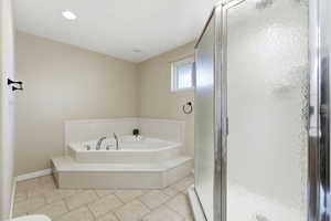 Full bath featuring a bath, a stall shower, and light tile patterned flooring