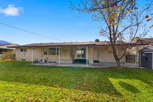 Back of property featuring a patio, brick siding, and a yard