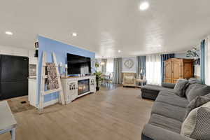 Living area with light wood-style floors and recessed lighting