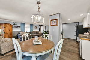 Dining area featuring a chandelier, recessed lighting, and dark wood finished floors