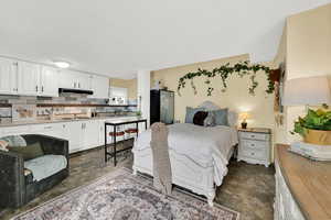 Bedroom featuring freestanding refrigerator and stone finish floors