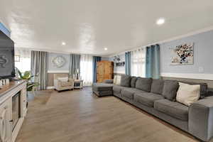 Living area featuring light wood-style flooring, recessed lighting, and plenty of natural light