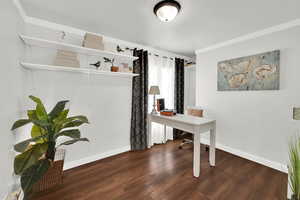 Office area featuring dark wood-type flooring and crown molding