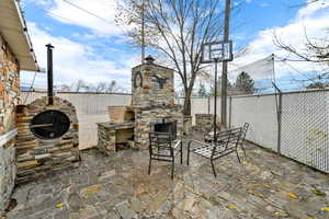 Fenced backyard with a fireplace and a patio
