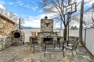 Fenced backyard with a fireplace, a patio area, and a mountain view
