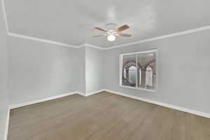 Unfurnished room featuring light wood-type flooring, crown molding, and ceiling fan