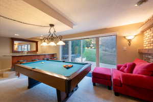 Recreation room featuring light carpet, billiards, and a fireplace