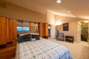 Bedroom featuring light carpet, recessed lighting, and high vaulted ceiling