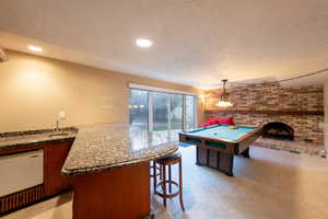 Game room with billiards, a brick fireplace, recessed lighting, light colored carpet, and walkout to beautiful backyard