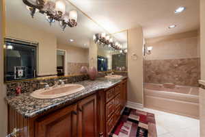 Bathroom featuring double vanity, a garden jacuzzi tub, light tile patterned floors, recessed lighting, and a shower