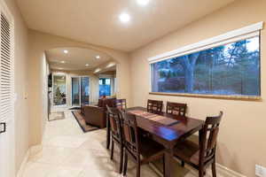 Dining space off kitchen with archways, recessed lighting, light tile patterned floors and views out to private backyard