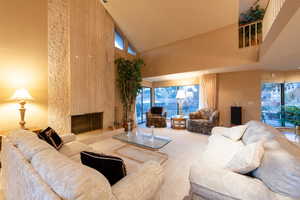 Lovely living room with vaulted ceilings, fireplace, and beautiful picture windows looking out to city and valley