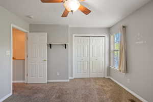 Unfurnished bedroom featuring carpet flooring, a ceiling fan, and a closet