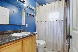 Full bathroom featuring vanity, a textured wall, shower / tub combo, and light tile patterned flooring