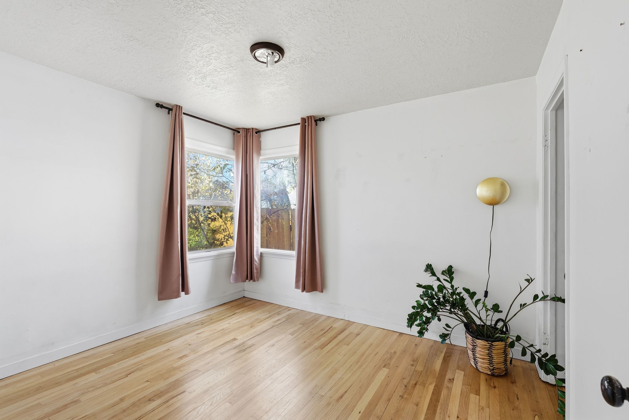 Empty room featuring a textured ceiling and light wood-type flooring