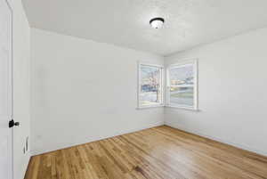 Spare room with a textured ceiling and light wood-style floors