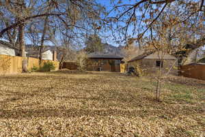 Fenced backyard with an outbuilding