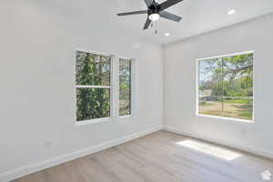 Empty room with light wood-type flooring, healthy amount of natural light, ceiling fan, and recessed lighting