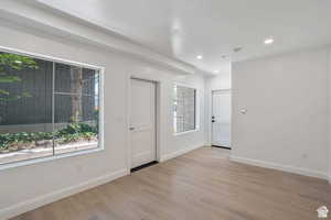 Empty room with light wood finished floors and recessed lighting
