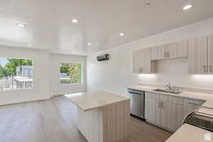 Kitchen with recessed lighting, a center island, light countertops, light wood-style flooring, and dishwasher