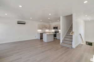 Kitchen featuring open floor plan, light countertops, a center island, appliances with stainless steel finishes, and recessed lighting