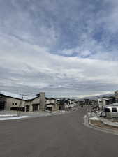 View of asphalt street featuring a residential view, sidewalks, and curbs