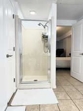 Bathroom featuring ensuite bathroom, a shower stall, and light tile patterned flooring
