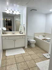 Bathroom with vanity, a stall shower, a garden tub, a textured ceiling, and light tile patterned flooring
