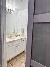 Bathroom with vanity, light tile patterned flooring, and a textured ceiling