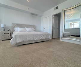 Bedroom featuring a textured ceiling and light colored carpet