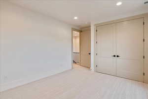 Unfurnished bedroom with recessed lighting, a closet, and carpet