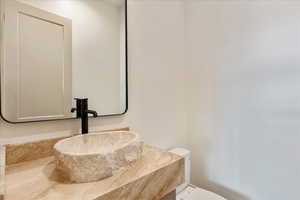 Half bathroom featuring vanity and toilet