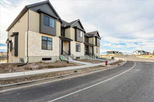 View of front of property with stone siding, a residential view, and board and batten siding