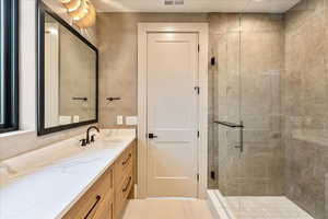 Full bath featuring a stall shower and vanity