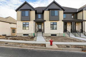 View of front of house with stone siding and board and batten siding